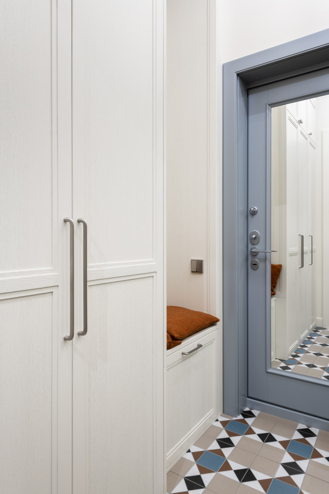 Inspiration pour une petite entrée design avec un couloir, un mur beige, un sol en carrelage de céramique, une porte grise et un sol gris.