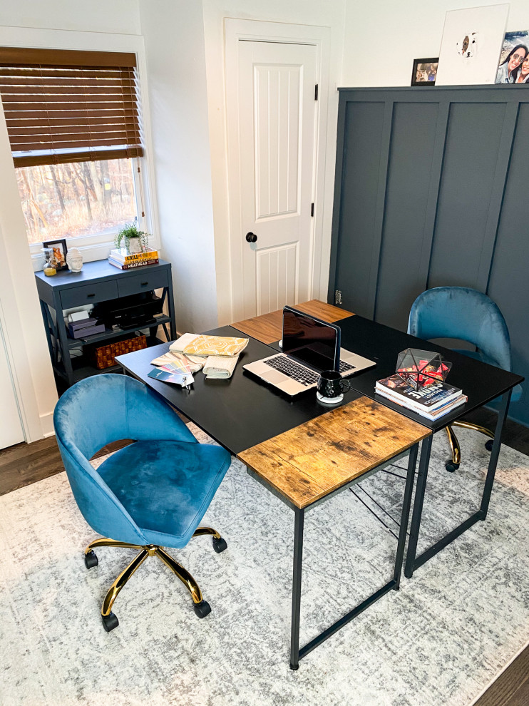 This is an example of a mid-sized eclectic study room in New York with blue walls, dark hardwood floors, a freestanding desk, brown floor and panelled walls.