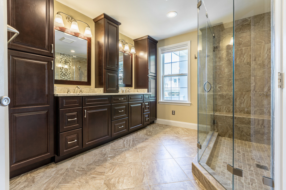 Design ideas for a mid-sized contemporary master bathroom in DC Metro with raised-panel cabinets, dark wood cabinets, a double shower, a one-piece toilet, beige tile, beige walls, an undermount sink, beige floor, a hinged shower door and beige benchtops.