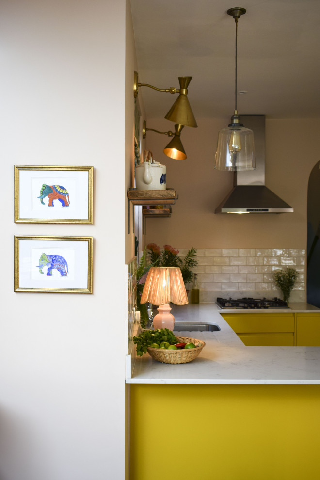 Idée de décoration pour une cuisine ouverte bohème de taille moyenne avec un placard à porte plane, des portes de placard jaunes, plan de travail en marbre et un plan de travail blanc.