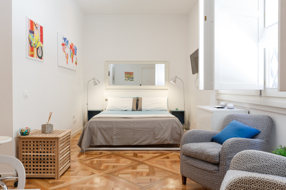 Photo of a large contemporary master bedroom in Rome with white walls and medium hardwood floors.