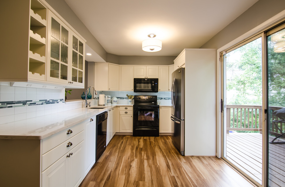 Inspiration for a mid-sized transitional l-shaped vinyl floor enclosed kitchen remodel in DC Metro with an undermount sink, shaker cabinets, quartz countertops, white backsplash, ceramic backsplash, black appliances and no island