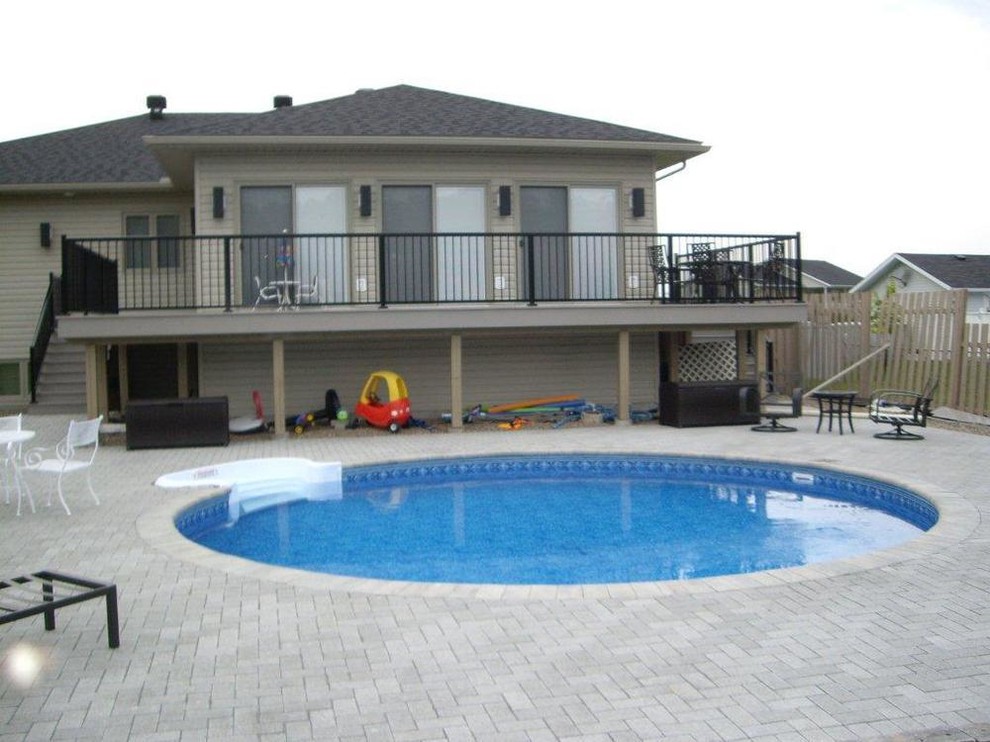 Example of a transitional courtyard tile and round pool design in Toronto