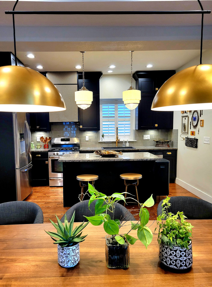 This is an example of an eclectic kitchen/diner in Denver with shaker cabinets, black cabinets, concrete worktops, grey splashback, an island and grey worktops.