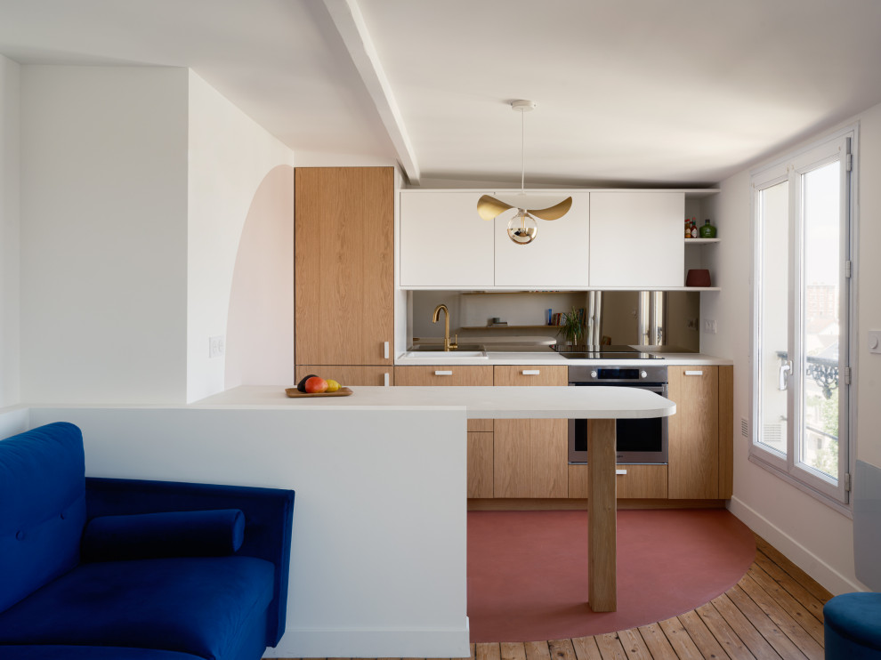 На фото: параллельная кухня в белых тонах с отделкой деревом в современном стиле с светлыми деревянными фасадами, столешницей из бетона, фартуком цвета металлик, зеркальным фартуком, бетонным полом, розовым полом и белой столешницей с