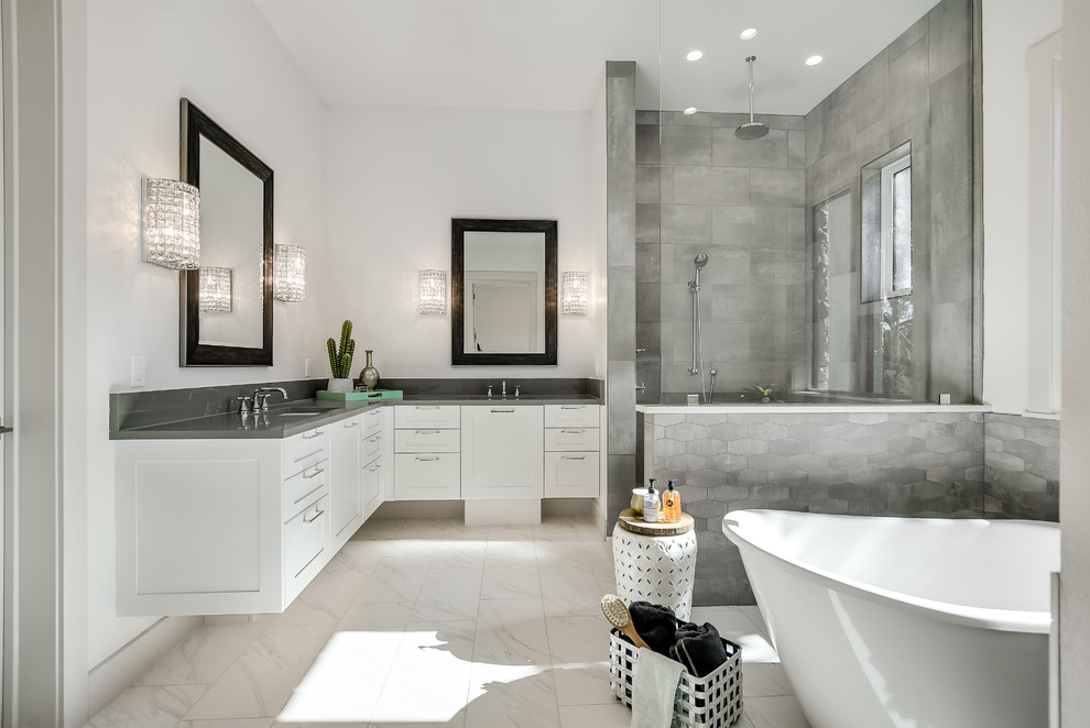 Design ideas for a transitional master bathroom in Austin with shaker cabinets, white cabinets, a freestanding tub, a corner shower, gray tile, white walls, an undermount sink, white floor and grey benchtops.