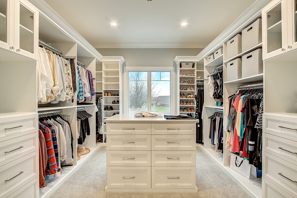 Inspiration for a transitional gender-neutral walk-in wardrobe in Milwaukee with recessed-panel cabinets, white cabinets, carpet and beige floor.