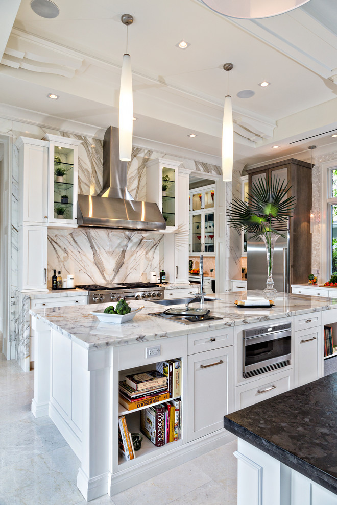 This is an example of a mid-sized contemporary galley separate kitchen in Miami with white cabinets, marble benchtops, white splashback, stone slab splashback, stainless steel appliances, an undermount sink, marble floors, shaker cabinets, with island and white floor.