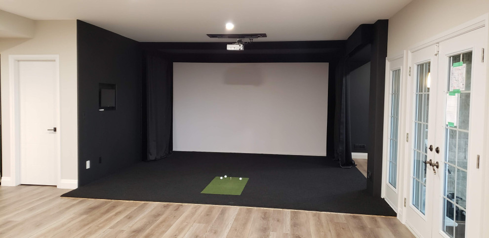 Example of a large transitional walk-out black floor basement game room design in Other