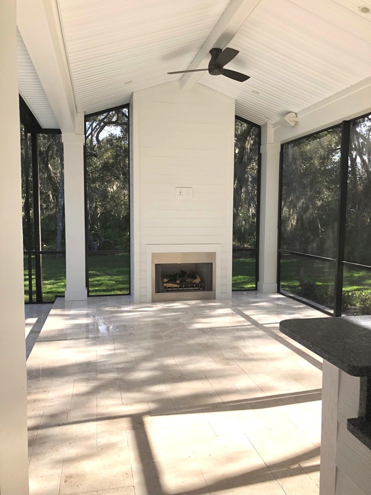 Large classic stone back porch idea in Jacksonville with a fire pit and a roof extension
