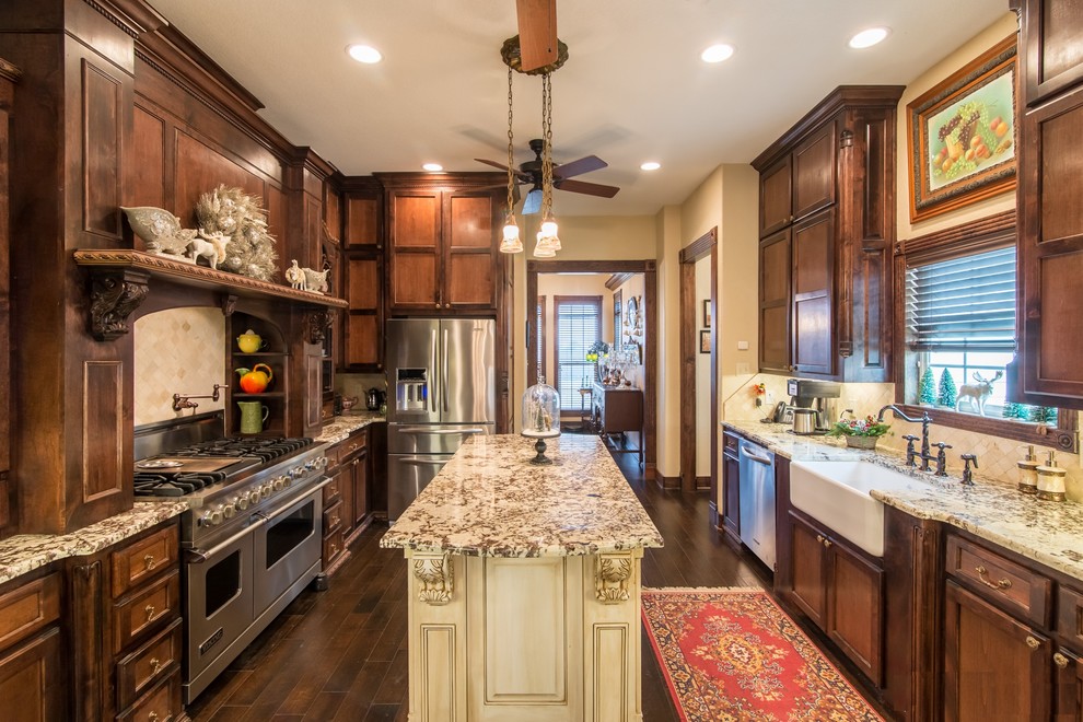 Inspiration for a large traditional u-shaped separate kitchen in Austin with a farmhouse sink, recessed-panel cabinets, dark wood cabinets, granite benchtops, beige splashback, travertine splashback, dark hardwood floors, with island and brown floor.