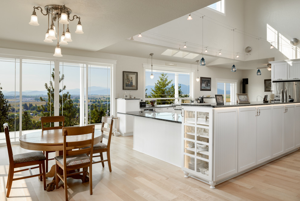 Inspiration for an expansive traditional open plan kitchen in Seattle with an undermount sink, white cabinets, marble benchtops, stainless steel appliances, light hardwood floors and with island.