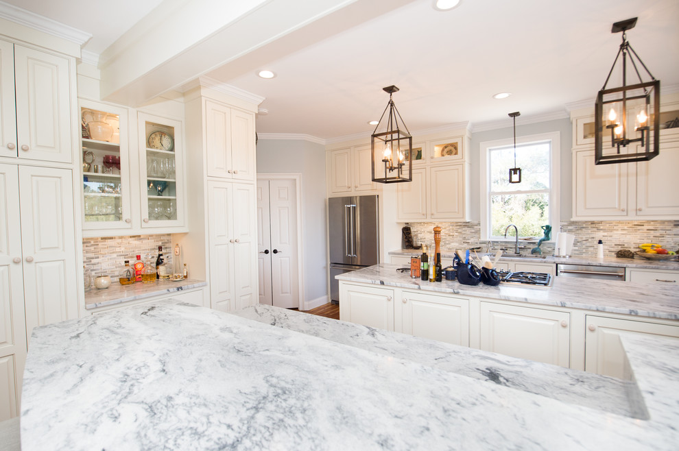 Inspiration for a large transitional u-shaped separate kitchen in Charleston with an undermount sink, raised-panel cabinets, white cabinets, quartzite benchtops, grey splashback, glass tile splashback, stainless steel appliances, medium hardwood floors and multiple islands.