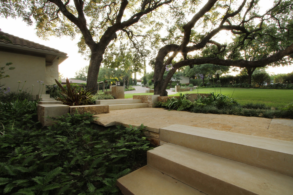 Large mediterranean front yard partial sun garden in Austin with natural stone pavers.