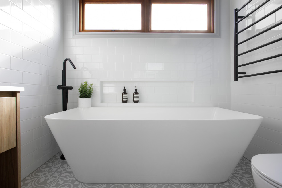 Idéer för ett mellanstort klassiskt vit en-suite badrum, med skåp i mellenmörkt trä, ett fristående badkar, vit kakel, keramikplattor, vita väggar, klinkergolv i keramik, bänkskiva i kvarts och grått golv