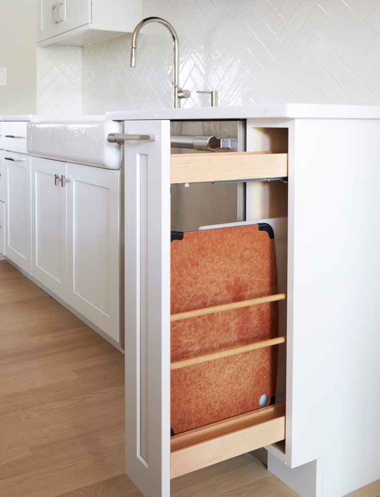 Inspiration for a large transitional u-shaped light wood floor, brown floor and coffered ceiling eat-in kitchen remodel in Chicago with a farmhouse sink, shaker cabinets, white cabinets, quartz countertops, white backsplash, subway tile backsplash, stainless steel appliances, an island and multicolored countertops