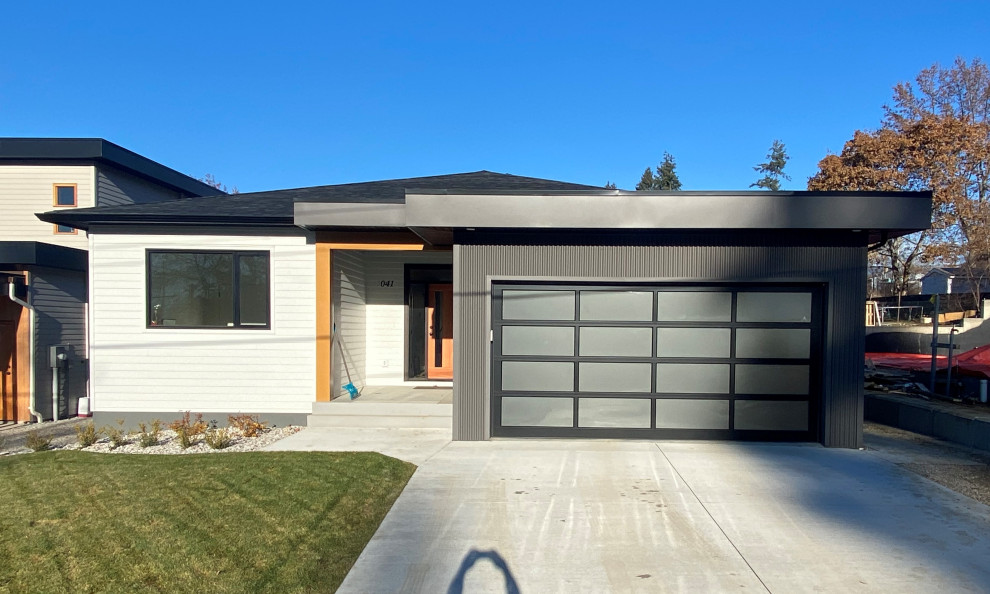 Kleines, Einstöckiges Modernes Einfamilienhaus mit Mix-Fassade, weißer Fassadenfarbe, Walmdach, Misch-Dachdeckung, schwarzem Dach und Verschalung in Vancouver