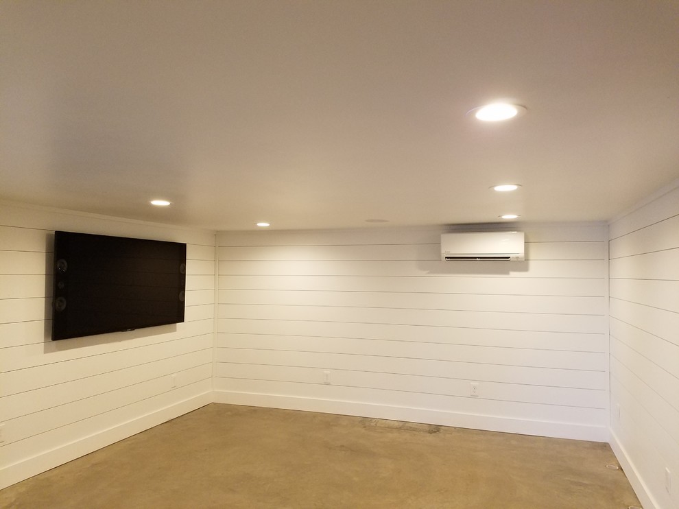 Design ideas for a large modern walk-out basement in Houston with white walls, concrete floors and grey floor.