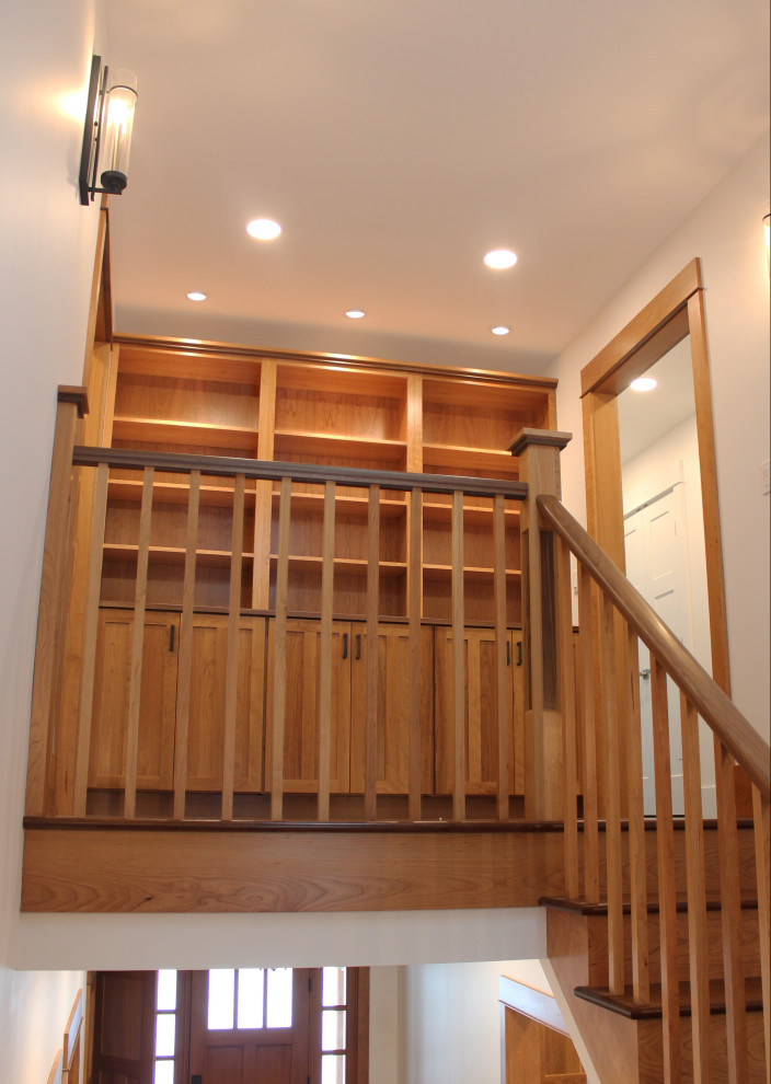Modelo de escalera en U de estilo americano grande con escalones de madera, contrahuellas de madera y barandilla de madera