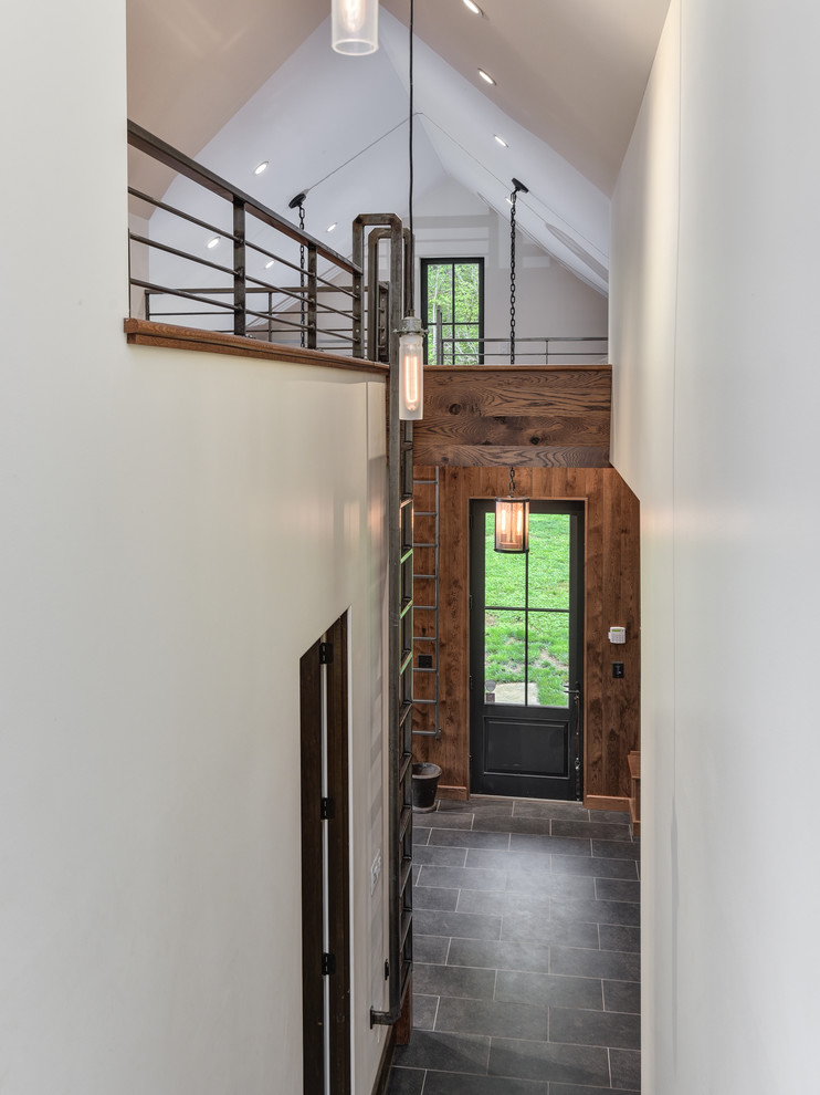 Inspiration for a large transitional u-shaped porcelain tile and gray floor home design remodel with shaker cabinets, medium tone wood cabinets, brown walls and a side-by-side washer/dryer