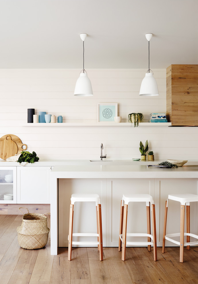This is an example of a mid-sized contemporary single-wall kitchen in Melbourne with recessed-panel cabinets, dark hardwood floors and with island.