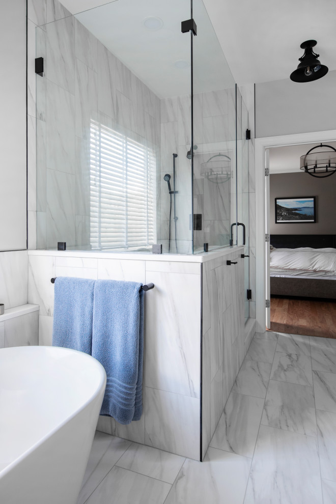 Пример оригинального дизайна: главная ванная комната среднего размера в классическом стиле с фасадами с утопленной филенкой, серыми фасадами, отдельно стоящей ванной, угловым душем, раздельным унитазом, белой плиткой, керамогранитной плиткой, серыми стенами, полом из керамогранита, врезной раковиной, столешницей из искусственного кварца, душем с распашными дверями, белой столешницей, тумбой под две раковины и подвесной тумбой