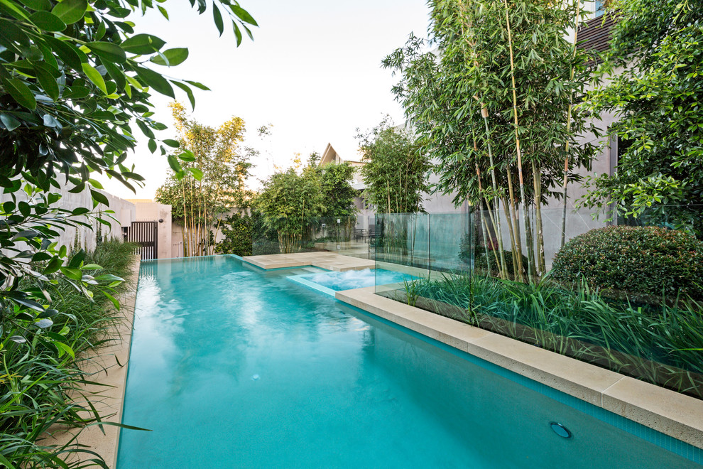 This is an example of a contemporary custom-shaped infinity pool in Melbourne with concrete pavers.