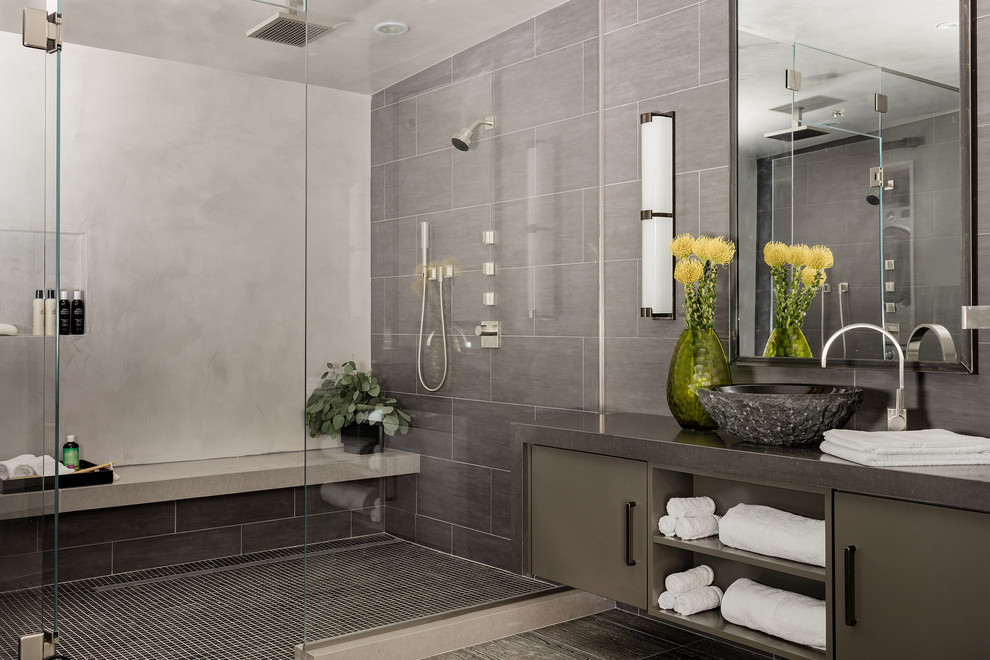 Design ideas for a large contemporary master bathroom in Boston with flat-panel cabinets, grey cabinets, gray tile, porcelain tile, grey walls, travertine floors, a vessel sink, engineered quartz benchtops, an alcove shower and a hinged shower door.