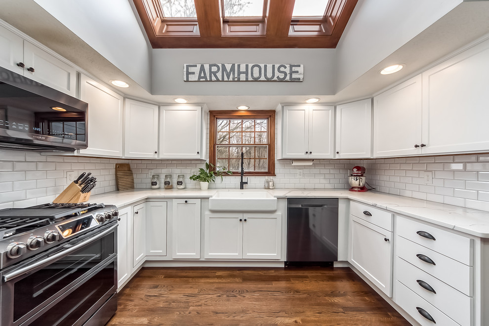 Example of a large transitional u-shaped eat-in kitchen design in Columbus with shaker cabinets, quartz countertops, white backsplash and an island