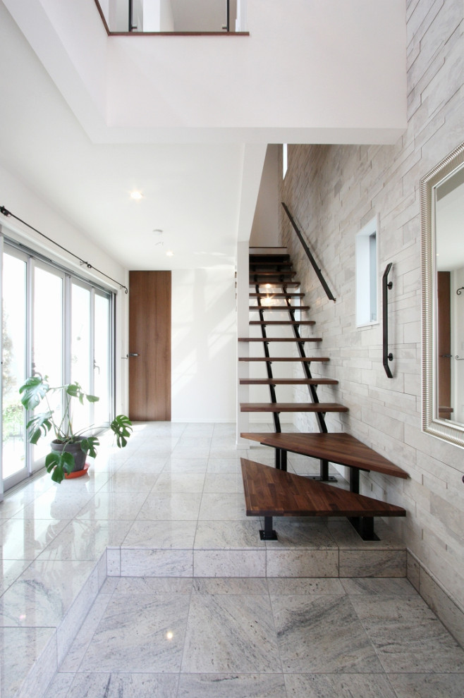 Пример оригинального дизайна: узкая прихожая среднего размера в стиле модернизм с белыми стенами, мраморным полом, одностворчатой входной дверью, входной дверью из темного дерева, серым полом, потолком с обоями и обоями на стенах
