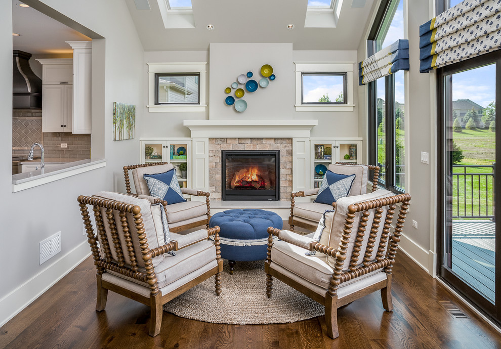 Mid-sized contemporary sunroom in Chicago with dark hardwood floors, a standard fireplace, a wood fireplace surround, a skylight and brown floor.