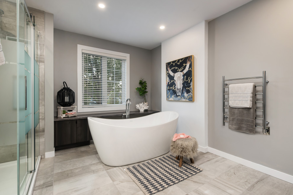 Large contemporary master bathroom in Montreal with flat-panel cabinets, brown cabinets, a freestanding tub, a corner shower, a one-piece toilet, gray tile, porcelain tile, grey walls, porcelain floors, a vessel sink, laminate benchtops, grey floor, a sliding shower screen and grey benchtops.