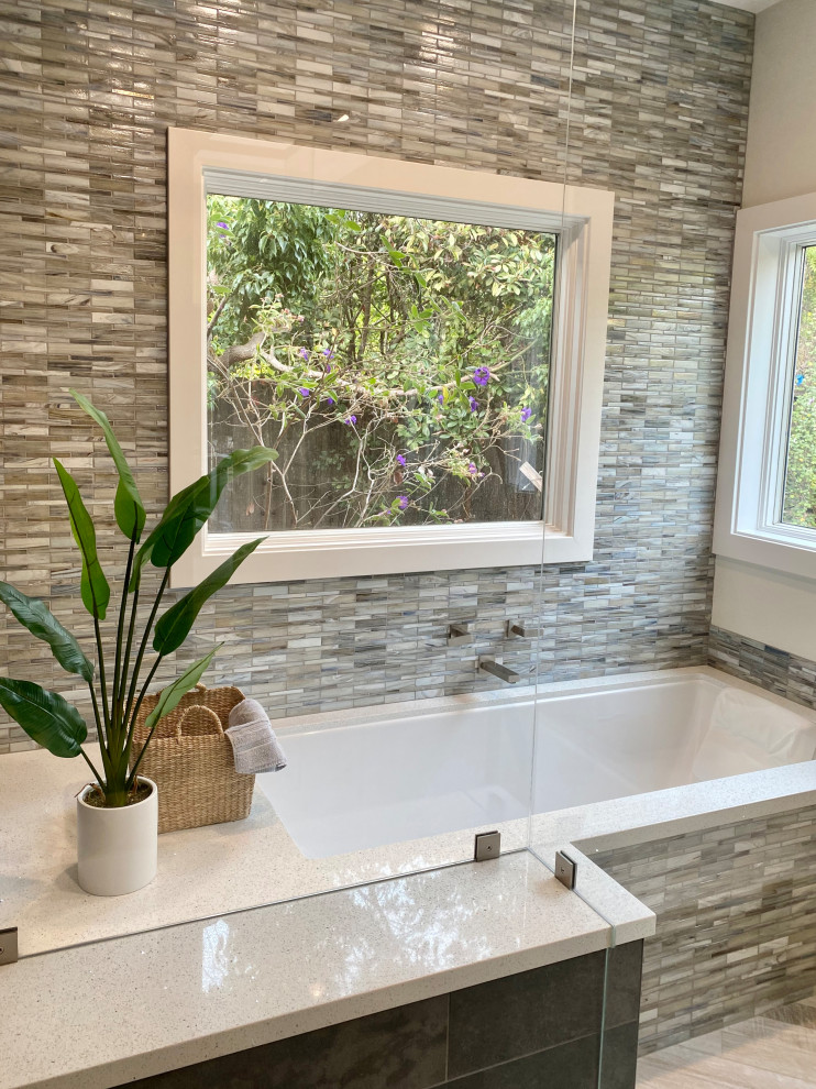 This is an example of a large contemporary master bathroom in San Francisco with flat-panel cabinets, medium wood cabinets, an undermount tub, a curbless shower, blue tile, beige walls, wood-look tile, an undermount sink, engineered quartz benchtops, multi-coloured floor, a hinged shower door, white benchtops, a shower seat, a double vanity and a floating vanity.