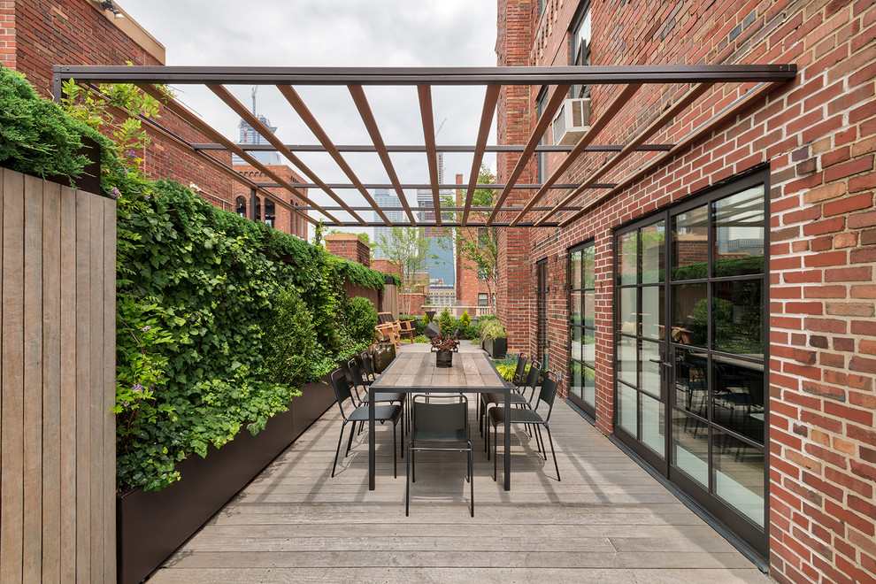 Photo of a large contemporary patio in New York with an awning, a vertical garden and decking.