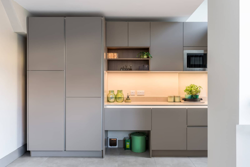 Стильный дизайн: отдельная, угловая кухня среднего размера в современном стиле с плоскими фасадами и черной техникой - последний тренд