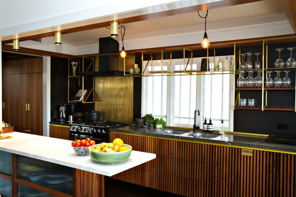 This is an example of an industrial galley eat-in kitchen in Brisbane with an undermount sink, louvered cabinets, medium wood cabinets, granite benchtops, black appliances and with island.