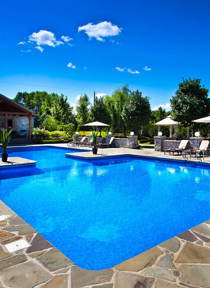 This is an example of a traditional custom-shaped pool in Montreal with natural stone pavers.