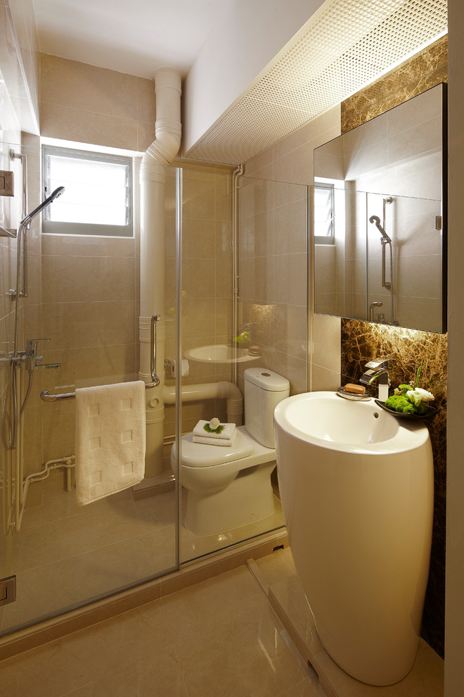This is an example of a small modern bathroom in Singapore with a pedestal sink, flat-panel cabinets, an alcove shower, a two-piece toilet, beige tile, porcelain tile, beige walls and porcelain floors.