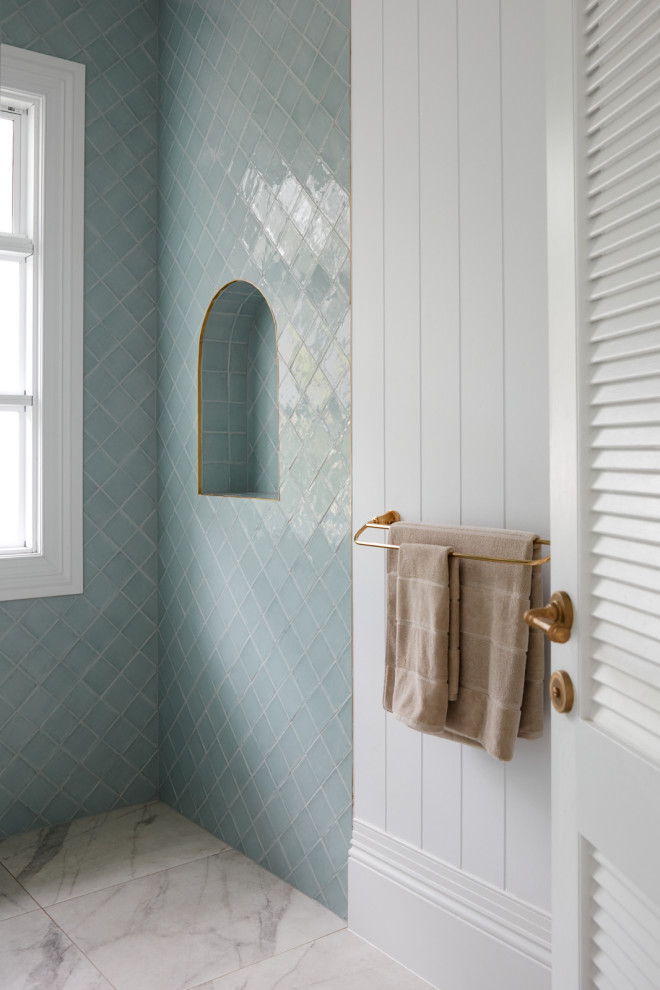 Exempel på ett mellanstort exotiskt vit vitt badrum, med luckor med upphöjd panel, vita skåp, en öppen dusch, en vägghängd toalettstol, blå kakel, keramikplattor, vita väggar, klinkergolv i porslin, ett fristående handfat och med dusch som är öppen