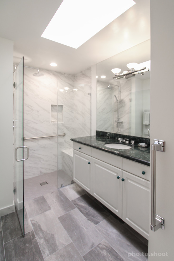 Photo of a mid-sized modern 3/4 bathroom in Los Angeles with white cabinets, a two-piece toilet, gray tile, ceramic tile, grey walls, ceramic floors, a drop-in sink, engineered quartz benchtops, grey floor, a hinged shower door, green benchtops, raised-panel cabinets, an alcove shower, a shower seat and a single vanity.
