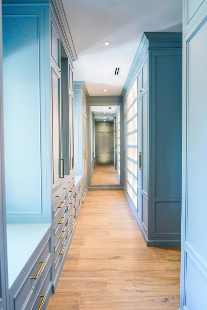 Стильный дизайн: гардеробная комната в стиле неоклассика (современная классика) с фасадами с выступающей филенкой и синими фасадами - последний тренд