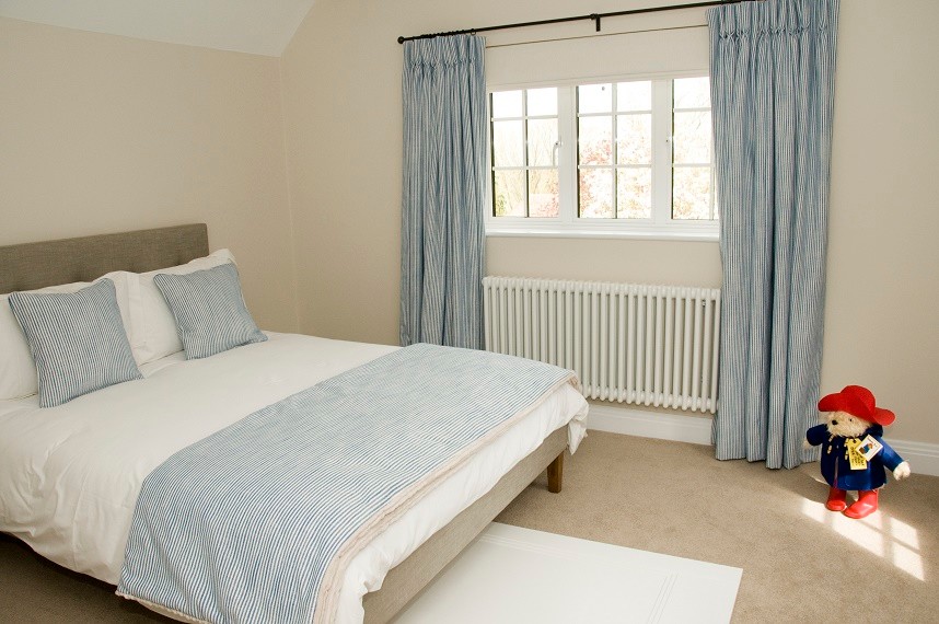 Inspiration for a mid-sized beach style guest bedroom in Surrey with beige walls and carpet.