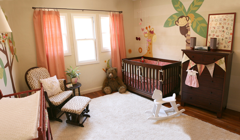 Photo of a contemporary gender-neutral nursery in San Diego with beige walls and dark hardwood floors.