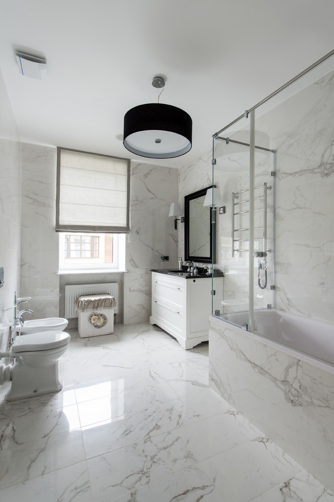 Design ideas for a traditional master bathroom in Moscow with recessed-panel cabinets, white cabinets, a shower/bathtub combo, a two-piece toilet, stone tile, white walls, marble floors and a hinged shower door.