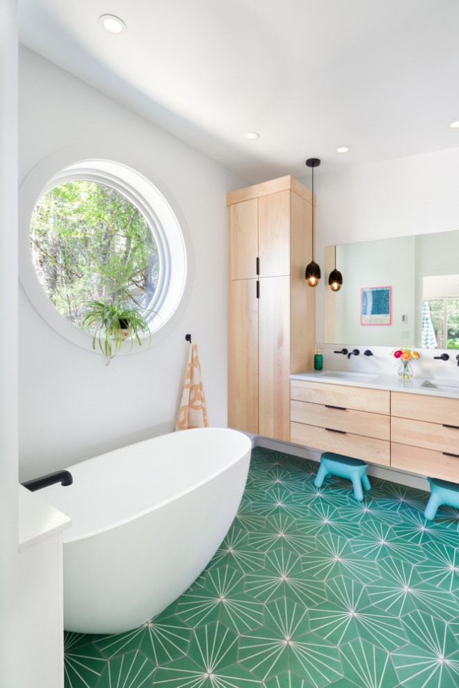 Eclectic bathroom in Denver with a freestanding tub, cement tiles, green floor, a hinged shower door, a double vanity and a floating vanity.