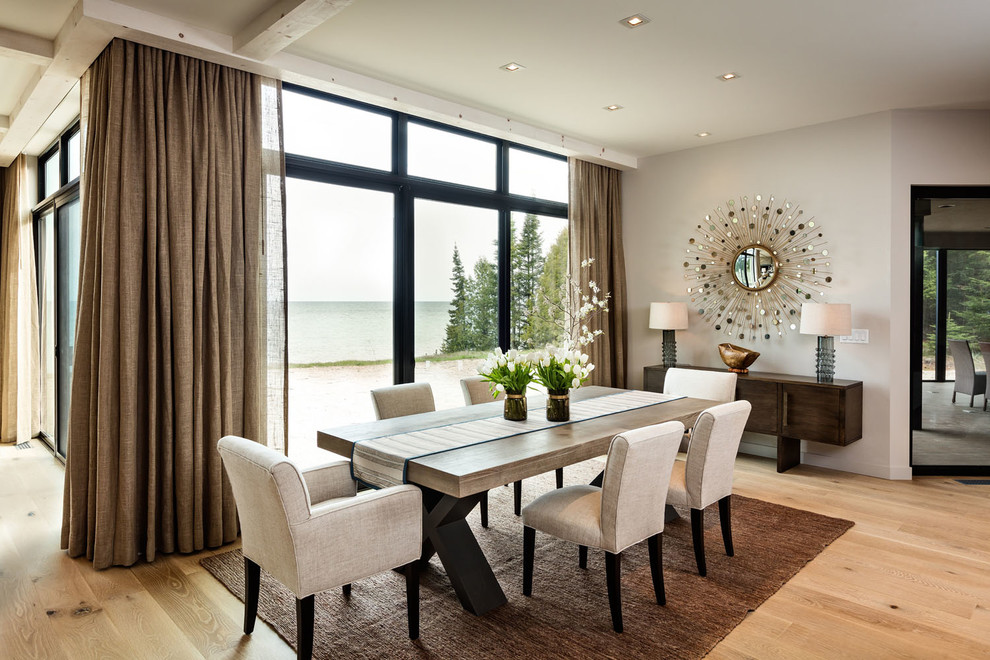 Photo of a large contemporary dining room in Milwaukee with beige walls, light hardwood floors, no fireplace and brown floor.