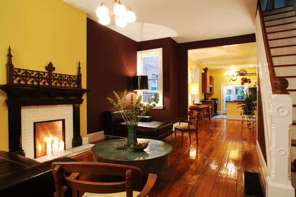 Photo of a mid-sized eclectic open concept living room in Philadelphia with yellow walls, medium hardwood floors and a tile fireplace surround.
