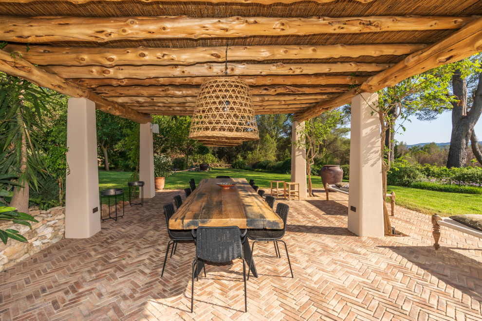 This is an example of a large mediterranean patio in Other with natural stone pavers.