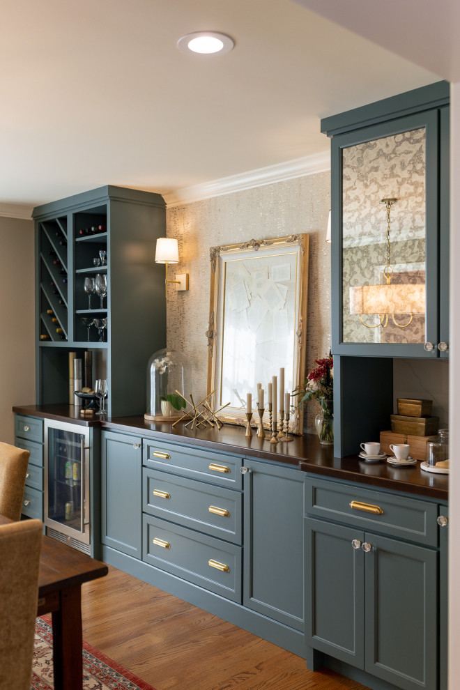 Example of a mid-sized transitional l-shaped medium tone wood floor and brown floor eat-in kitchen design with an undermount sink, medium tone wood cabinets, quartz countertops, beige backsplash, terra-cotta backsplash, stainless steel appliances, an island, white countertops and recessed-panel cabinets