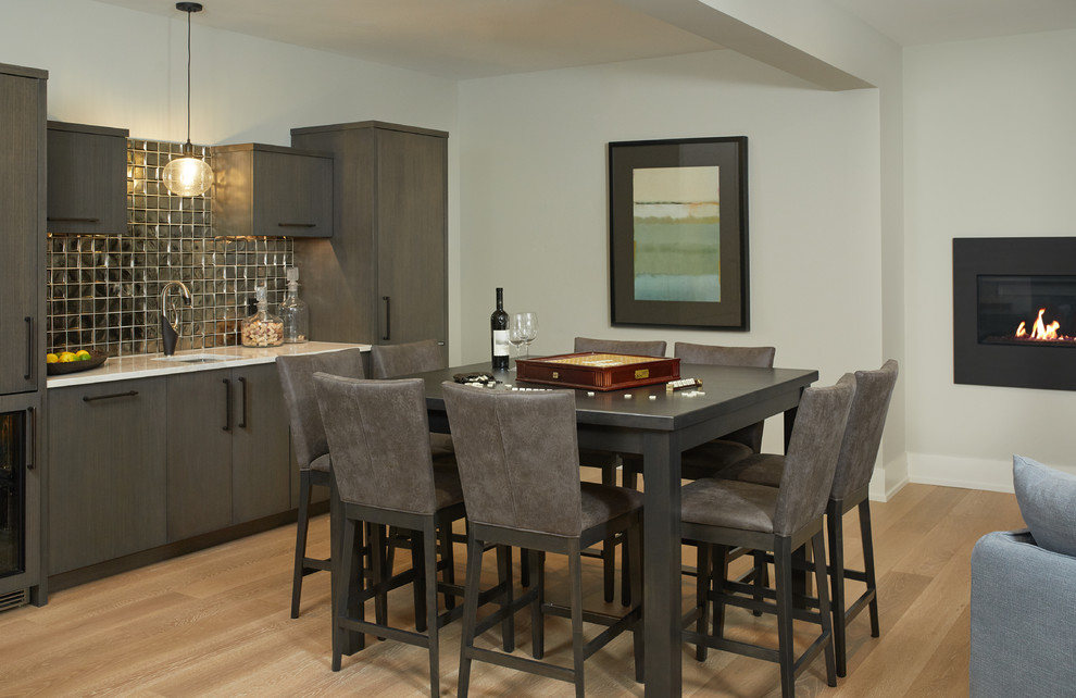 Photo of a large transitional open plan dining in Grand Rapids with light hardwood floors, a metal fireplace surround, grey walls, a ribbon fireplace and brown floor.